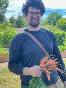 Zac holding carrots from garden 