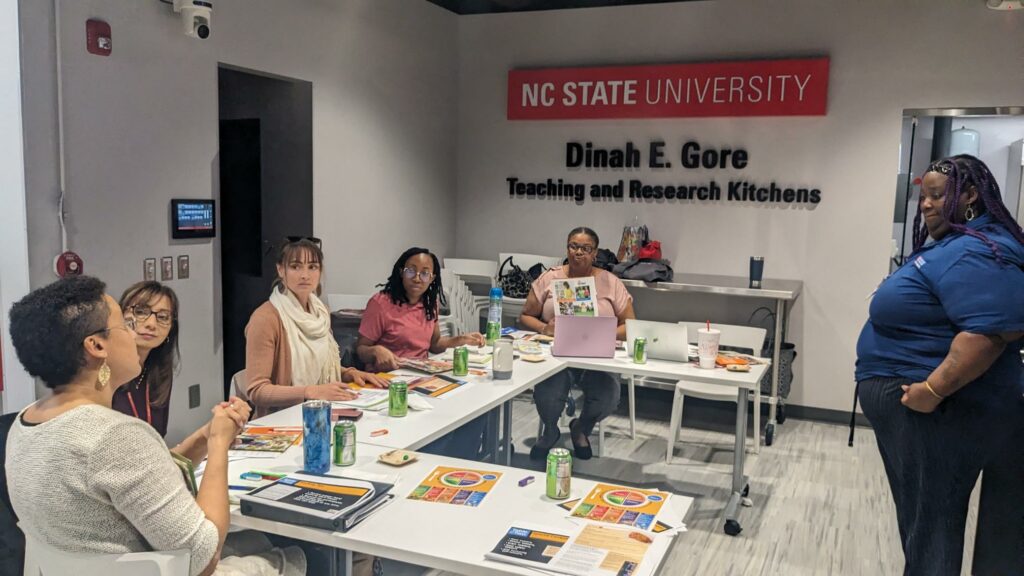 Staff seated at a table in the Dinah E. Gore Teaching and Research Kitchen