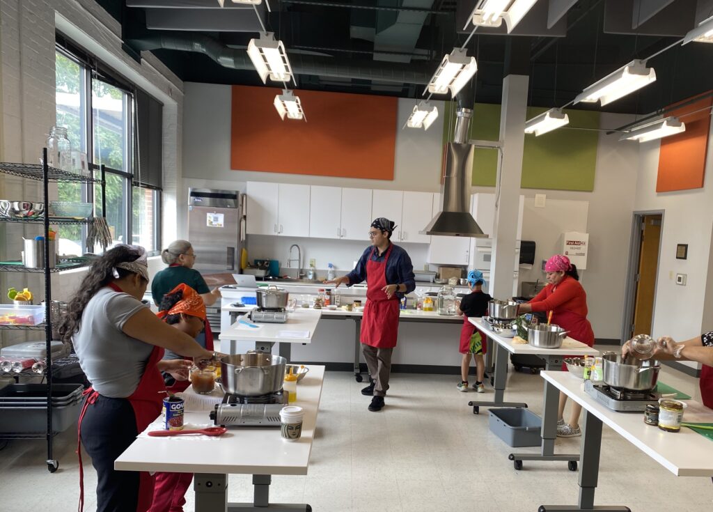 Mac teaching participants in kitchen