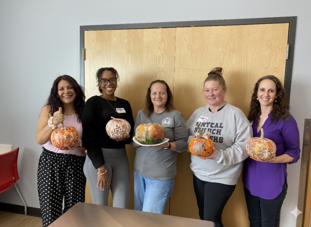 staff holding decorated pumpkins